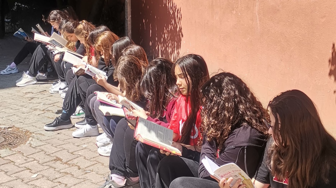 8-h Sınıfı bahçede kitap okuyor.